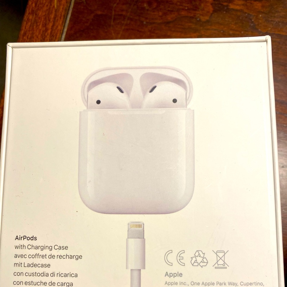 Apple AirPods with a sage green silicone case.